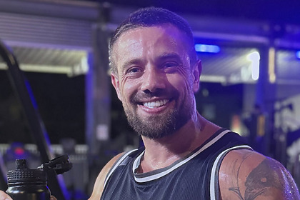 Rafael Cardoso sorridente em foto posada na academia