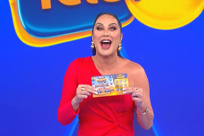 Helen Ganzarolli de vestido vermelho segura bilhete da Tele Sena de Pais 2026