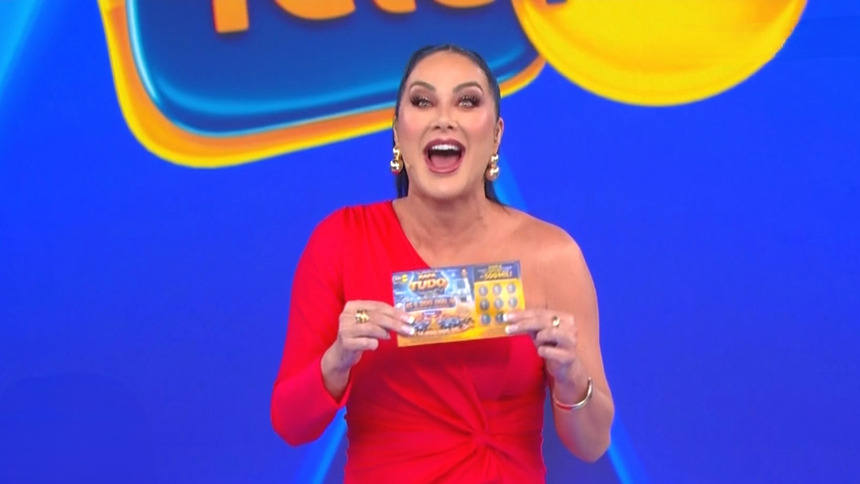 Helen Ganzarolli de vestido vermelho segura bilhete da Tele Sena de Pais 2026