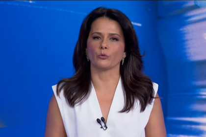 Adriana Araujo com semblante sério sentada na bancada do Jornal da Band lendo a nota de Janja contra Renan