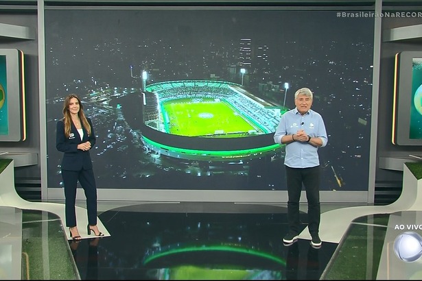 Paloma Tocci e Cleber Machado em pé no cenário do Brasileirão Na Record