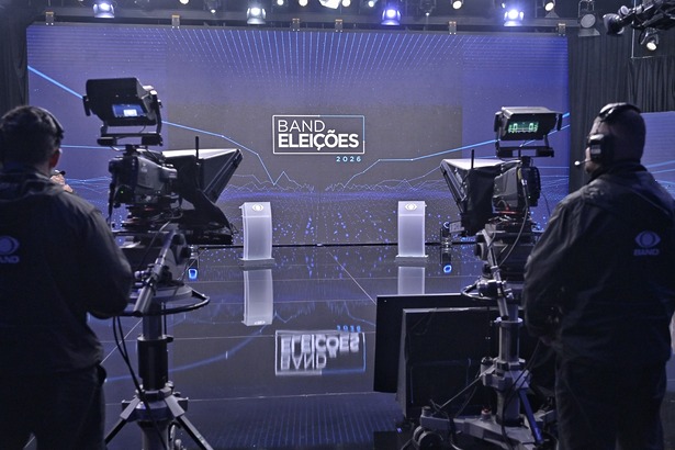 Estúdio Do Debate da Band nas Eleições 2026 um grande telão com cores azuis predominantes e dois púlpitos onde ficam os candidatos