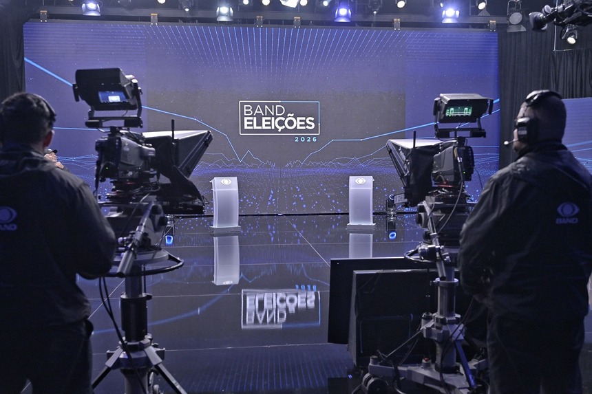 Estúdio Do Debate da Band nas Eleições 2026 um grande telão com cores azuis predominantes e dois púlpitos onde ficam os candidatos