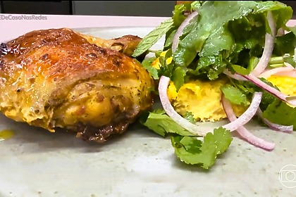 Frango Assado Com Pamonha Assada em cima de um prato cinza na bancada do É de Casa