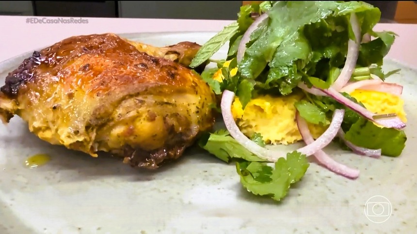 Frango Assado Com Pamonha Assada em cima de um prato cinza na bancada do É de Casa