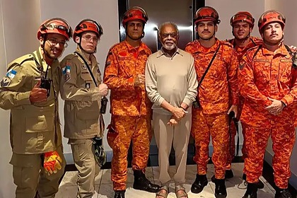 Gilberto Gil posando com o Corpo de Bombeiros após ser salvo do elevador