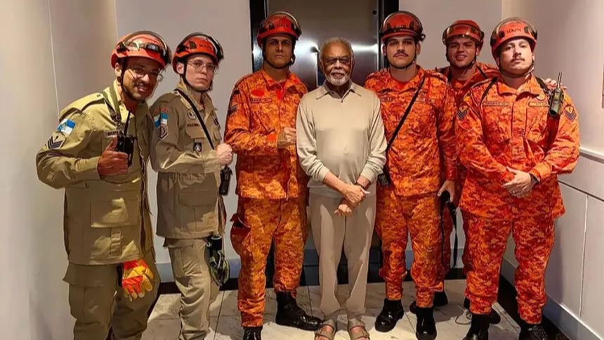 Gilberto Gil posando com o Corpo de Bombeiros após ser salvo do elevador