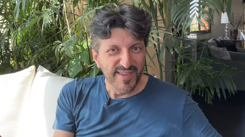 Influenciador Lito Sousa em frente a um pequeno jardim de coqueiros
