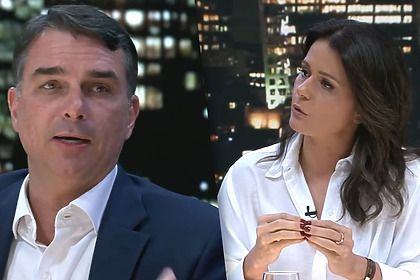 Flavio Bolsonaro olha para Adriana Araujo com a boca aberta, ambos sentados na bancada do Canal Livre na Band