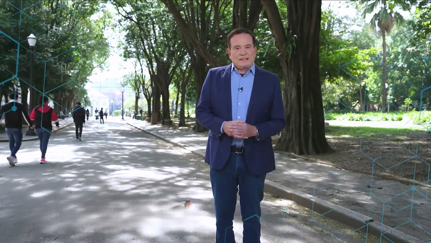 Roberto Cabrini em uma praça vestindo terno caminha em gravação da chamada do Domingo Espetacular