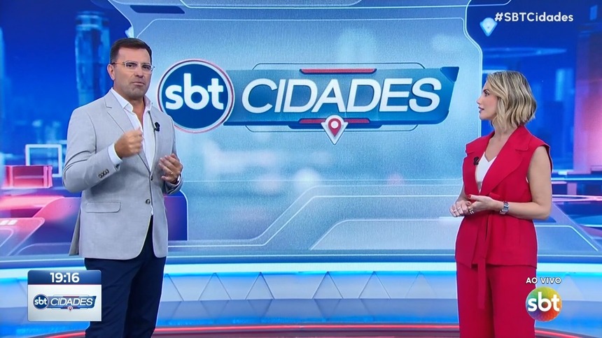 Rodrigo Bocardi e Erica Reis em pé no cenário do SBT Cidades