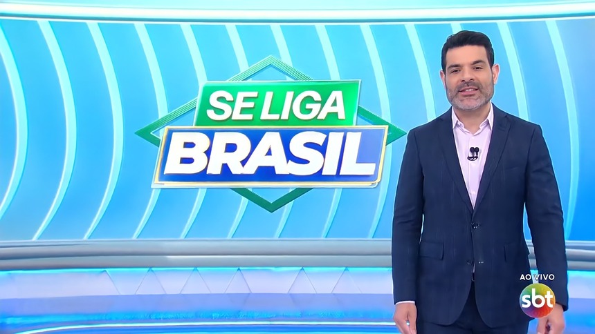 Darlisson Dutra sorrir em frente ao telão do Se Liga Brasil no SBT