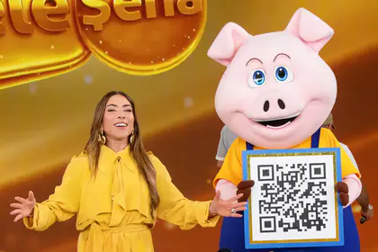Patricia Abravanel abre os braços ao lado do porquinho da Tele Sena dos Pais 2026