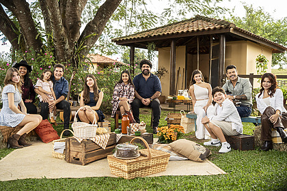 Daniel com as filhas; Fabiano Menotti e Marcos com os filhos sentados na área verde externa da fazenda no Viver Sertanejo