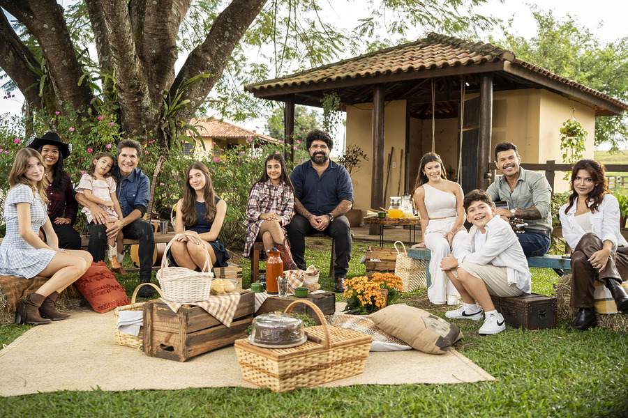 Daniel com as filhas; Fabiano Menotti e Marcos com os filhos sentados na área verde externa da fazenda no Viver Sertanejo