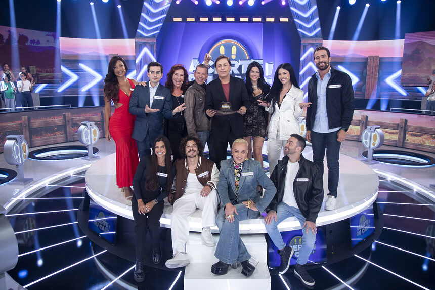 Elenco de ex-participantes de A Fazenda com Tom Calvante segurando o chapéu de fazendeiro no palco do Acerte Ou Caia!