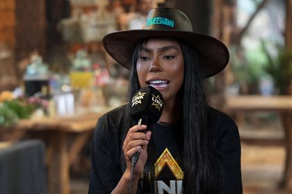 Carol Lekker segura microfone do Link Podcast na coletiva de A Fazenda 18