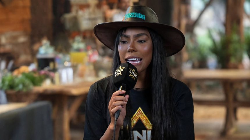 Carol Lekker segura microfone do Link Podcast na coletiva de A Fazenda 18