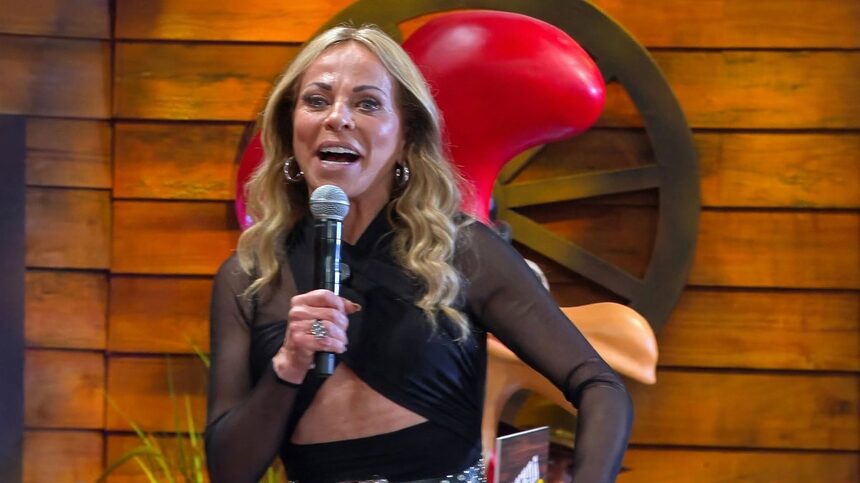 Christina Rocha sorridente em frente ao mascote de A Fazenda