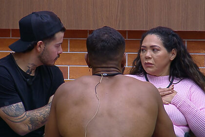 Darlin olha sério para Jottapê e Rikardo na sala de A Fazenda