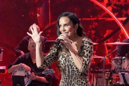 Ivete Sangalo levanta a mão enquanto canta no palco do Domingão com Huck