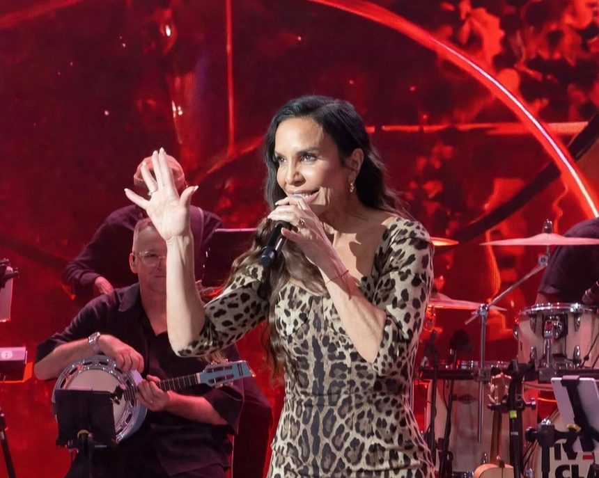 Ivete Sangalo levanta a mão enquanto canta no palco do Domingão com Huck