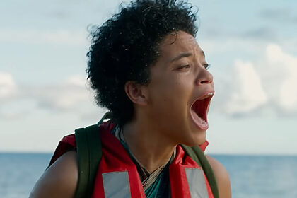 Mulher negra grita com a boca aberta na frente de um mar em cena do filme O Mistério Da Ilha