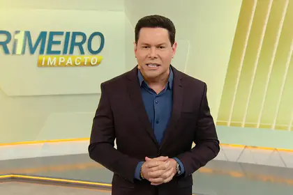 Marcão do Povo em pé no centro do cenário do Primeiro Impacto, no SBT