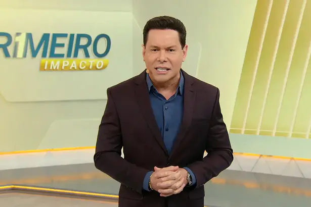 Marcão do Povo em pé no centro do cenário do Primeiro Impacto, no SBT