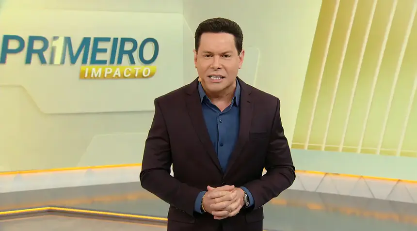Marcão do Povo em pé no centro do cenário do Primeiro Impacto, no SBT