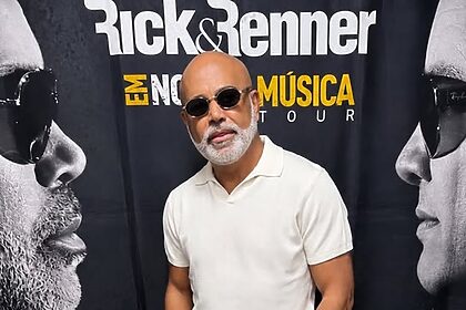 Cantor Rick Sollo posando em frente ao telão da dupla