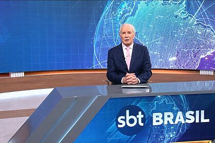 Celso Freitas sentado na bancada do SBT Brasil