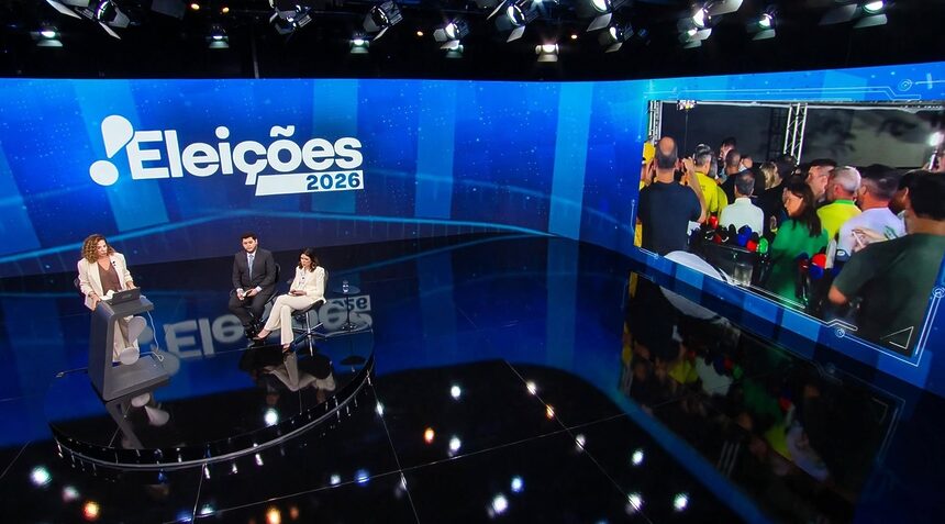 Fabíola Cidral, em pé no centro do cenário da cobertura das Eleições 2026 na RedeTV!